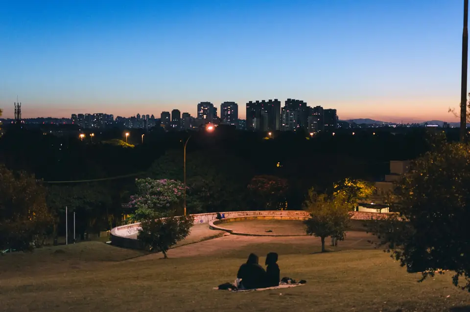 Praça pública ao entardecer com a cidade ao fundo
